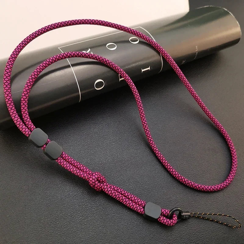 Geflochtenes Handy-Lanyard in kräftigem Magenta-Schwarz, schwarze Stopperwürfel und Knoten, Draufsicht