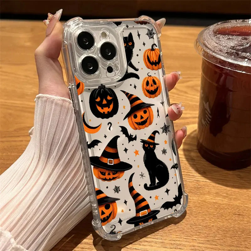 Hand hält transparente iPhone-Hülle mit schwarzen Katzen im Hexenhut, orangefarbenen Kürbissen und Spinnweben