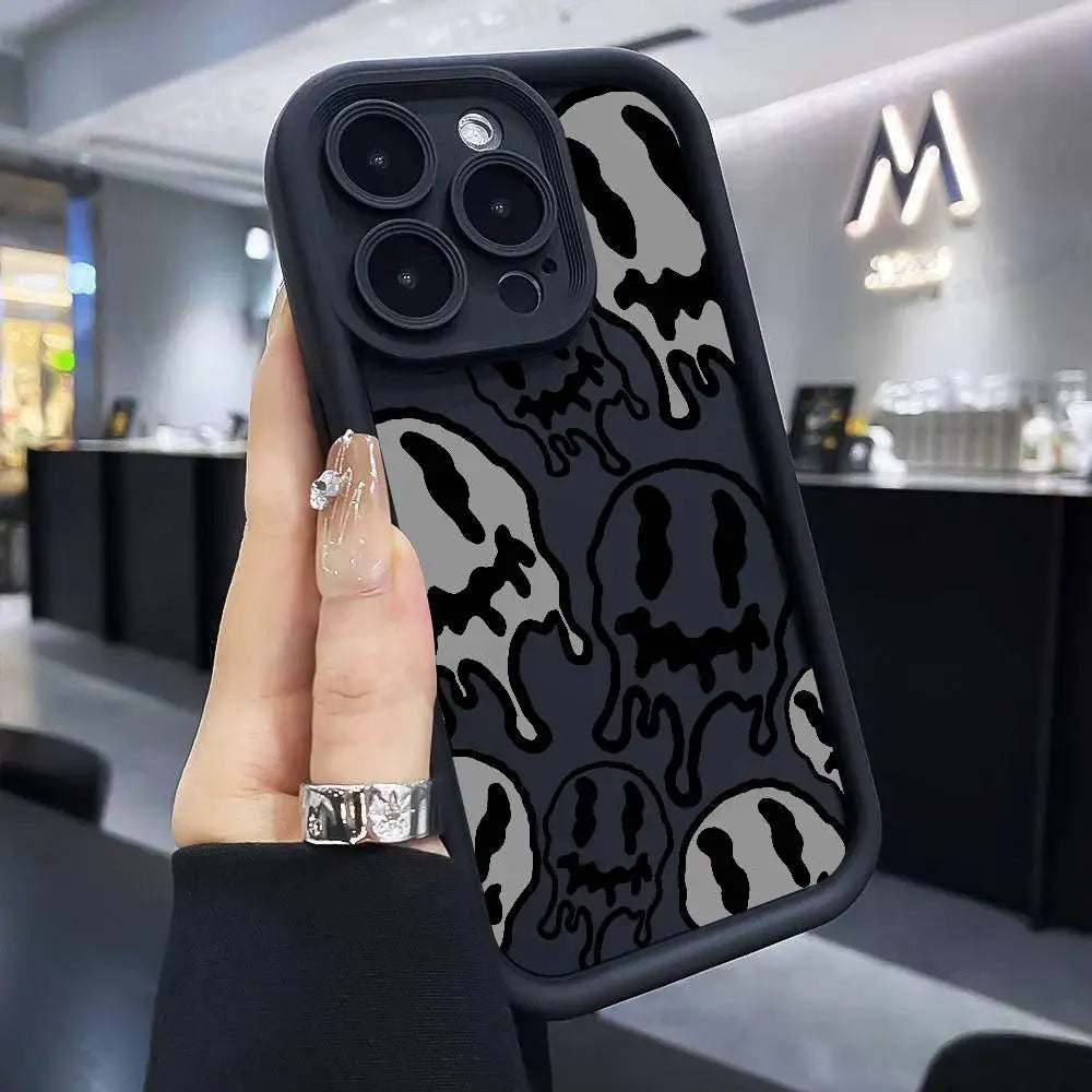 Hand hält schwarze iPhone-Hülle mit grau-schwarzem Dripping-Smiley-Allover-Print, Rückansicht