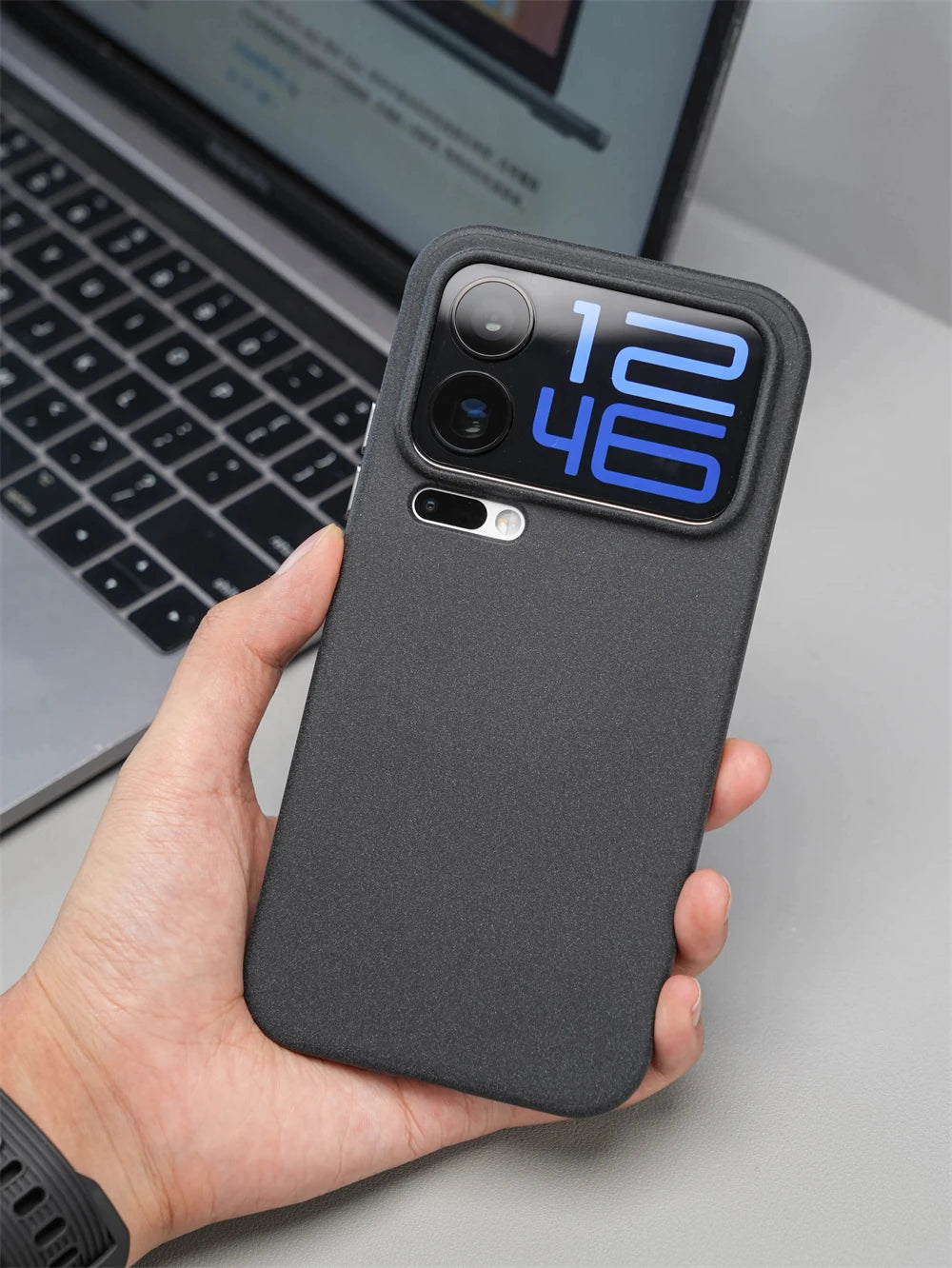 Hand hält Smartphone mit schwarzer matter Silikonhülle, Rückseite mit freigegebenem Kamera-Display sichtbar