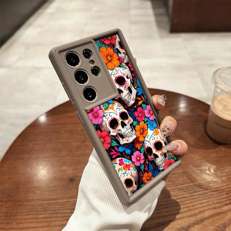 Hand hält graue Samsung-Hülle mit bunten Sugar-Skull-Totenköpfen und orangefarbenen sowie pinken Blüten, Rückansicht