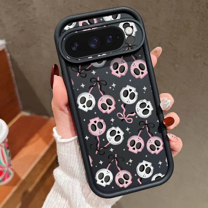 Hand hält schwarze Google Pixel Hülle mit rosa-weißen Schädeln und schwarzen Schleifen auf dunklem Hintergrund
