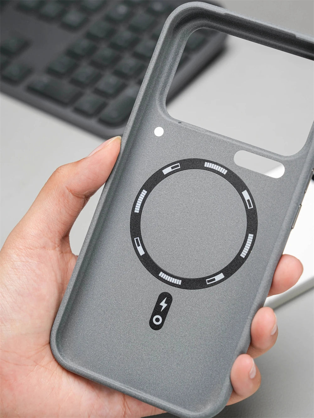 Innenseite der grauen Hülle mit rundem Magnetring-Print für Wireless Charging, in der Hand gehalten