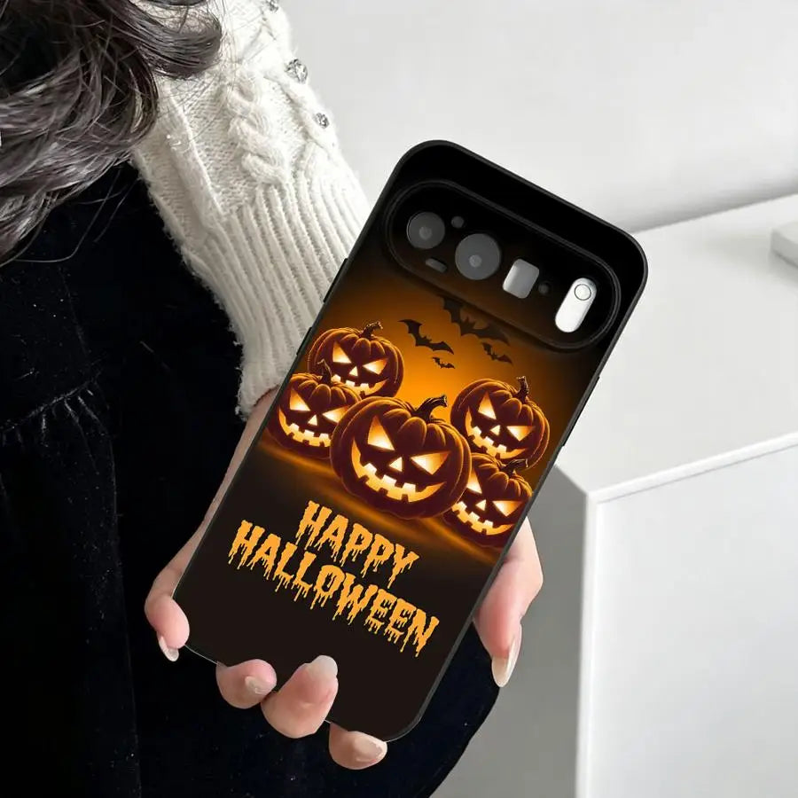 Frauenhand hält schwarze Pixel-Hülle mit glühenden Jack-o'-Lanterns, Fledermäusen und Happy-Halloween-Schriftzug