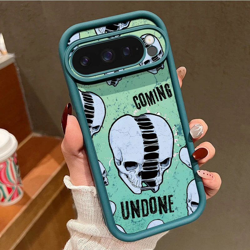 Hand hält türkisfarbene Google Pixel Hülle mit Schädel-Motiv und Aufschrift 'Coming Undone', dunkler TPU-Rahmen
