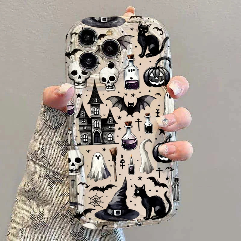 Hand hält transparente iPhone-Hülle mit Halloween-Motiven: Totenköpfe, Geister, Kürbisse, schwarze Katze und Hexenhaus