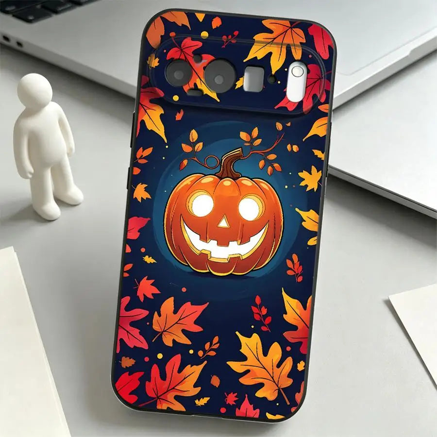 Schwarze Google-Pixel-Hülle mit leuchtendem Kürbis-Gesicht auf dunkelblauem Herbstlaub-Muster, Schrägansicht