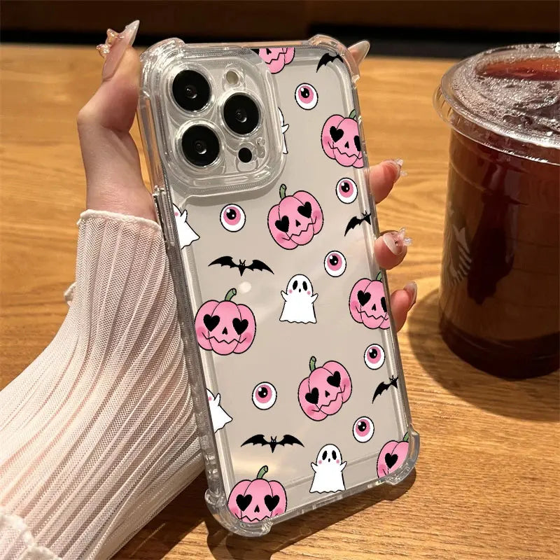 Hand hält transparente iPhone-Hülle mit pinken Kürbissen, weißen Geistern, Fledermäusen und roten Augen-Motiven