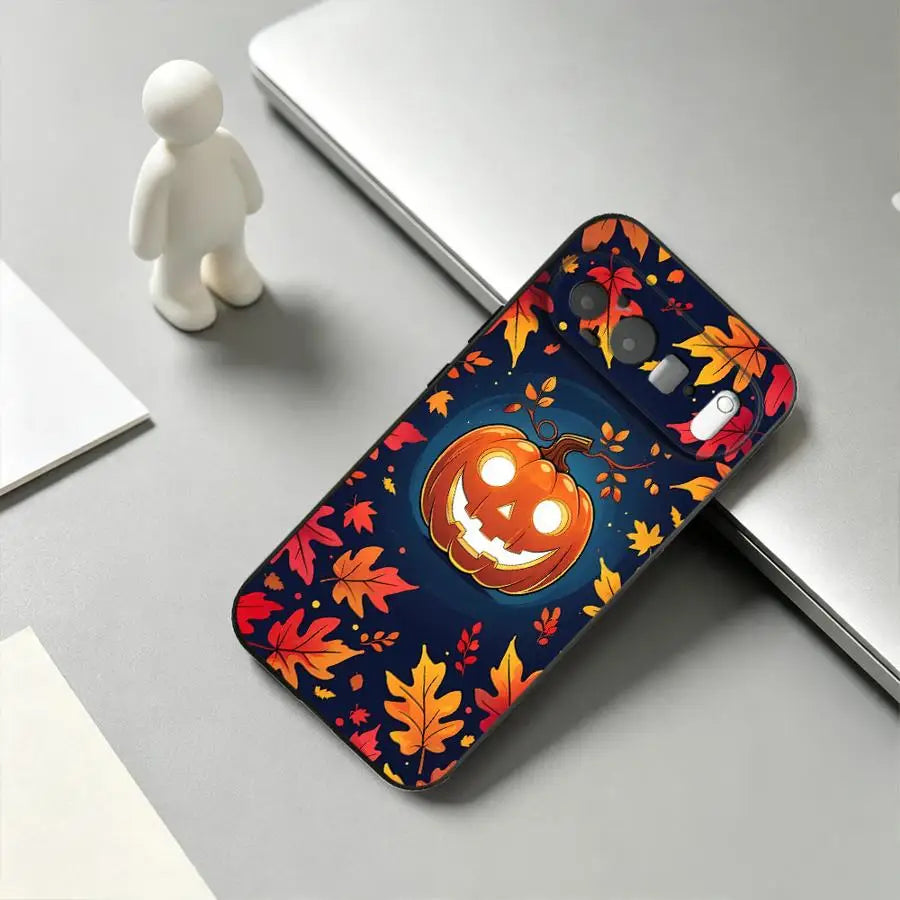 Schwarze Google-Pixel-Hülle mit lächelndem Halloween-Kürbis auf dunkelblauem Herbstlaub-Hintergrund, Schrägansicht