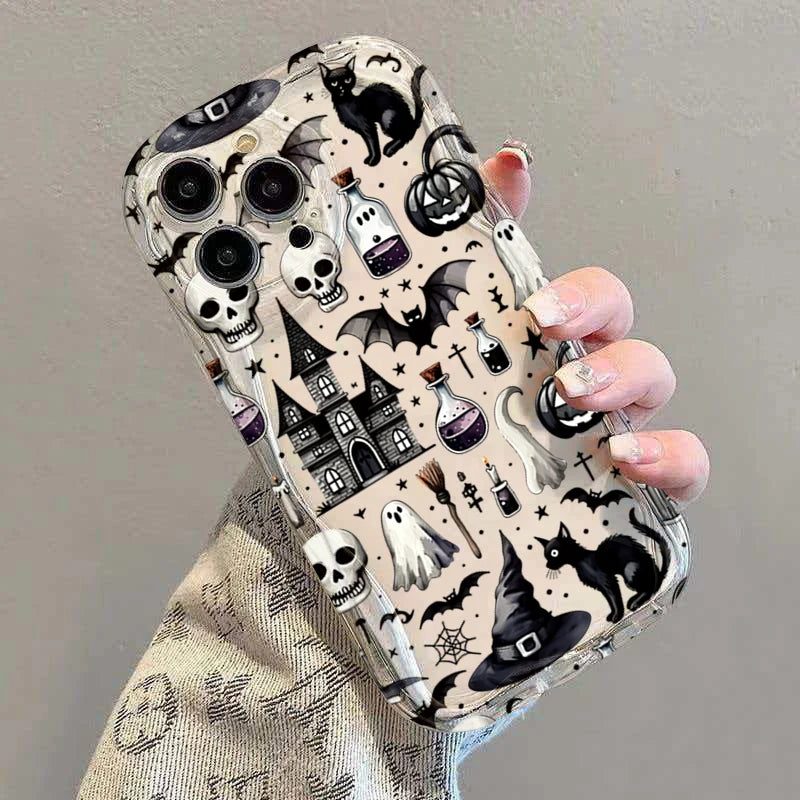 Schrägansicht: Hand hält transparente iPhone-Hülle mit Halloween-Allover-Print – Totenköpfe, Hexenhaus, Geister und schwarze 