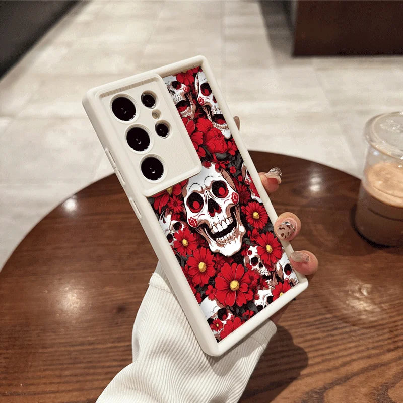 Hand hält weiße Samsung-Hülle mit weißen Totenköpfen und roten Blüten, auffälliges Gothic-Blumendesign