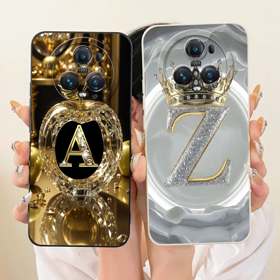 Zwei Honor Magic 5 Hüllen in Hand: goldenes Design mit Buchstabe A im Kristallherz, graues Design mit glitzerndem Z und Goldk