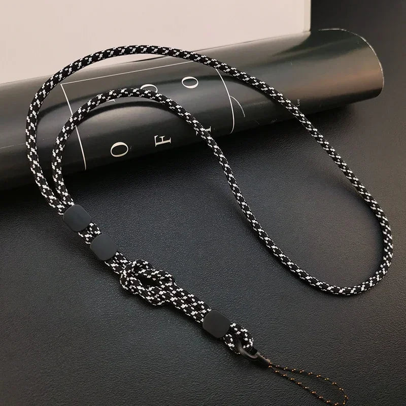 Schwarz-weißes meliertes Handy-Nackenband, geflochtenes Seil mit schwarzen Stopper-Perlen und Verstellknoten, Draufsicht