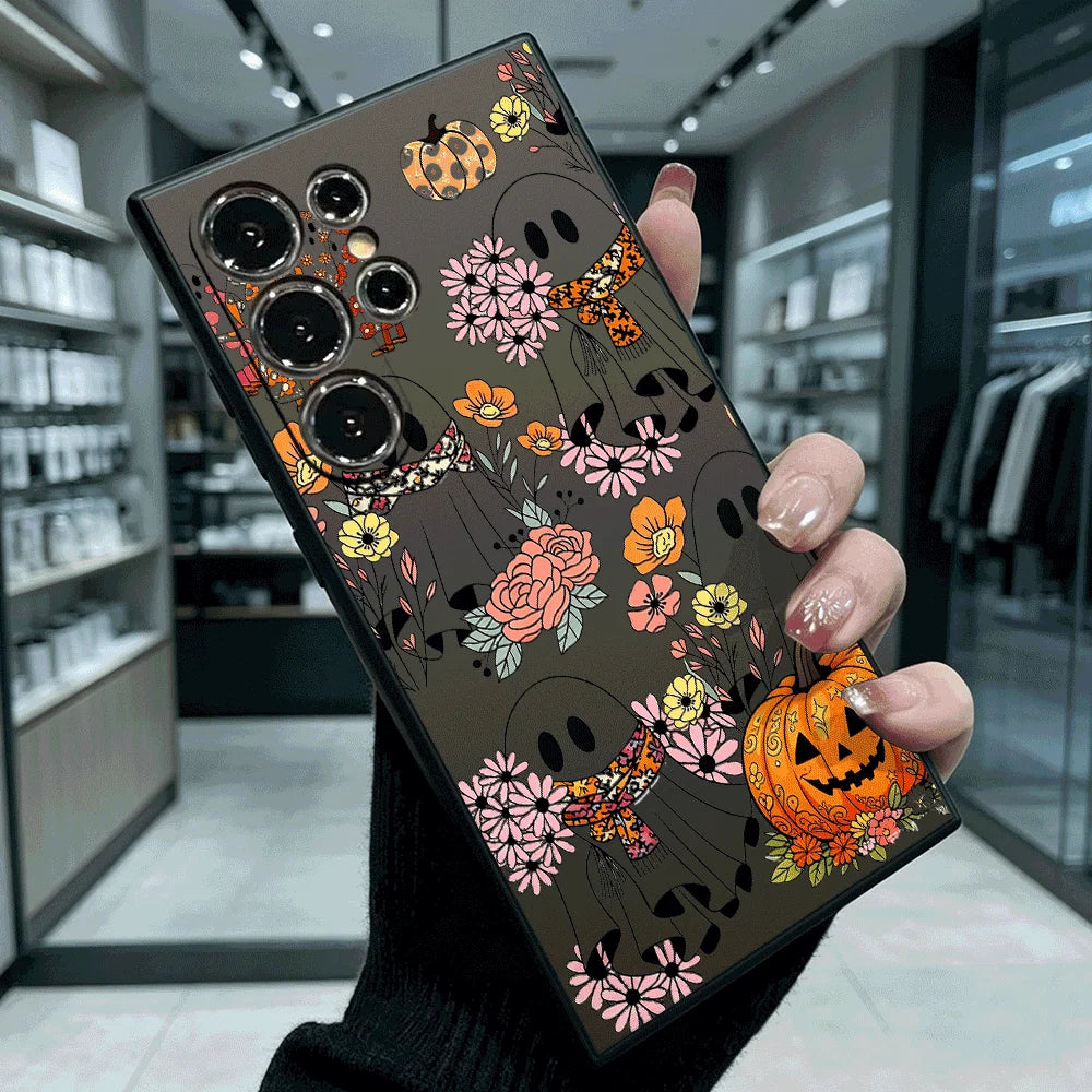 Schwarze TPU-Schutzhülle für Samsung Galaxy mit Geistern, bunten Blumen und leuchtendem Kürbis-Motiv, in Hand gehalten