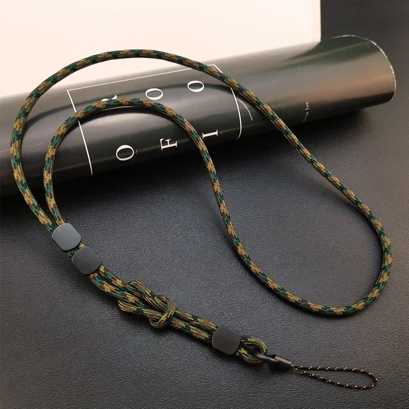 Geflochtenes Lanyard in Grün-Braun-Schwarz-Camouflage mit Knoten, schwarzen Stoppern und Karabinerhaken