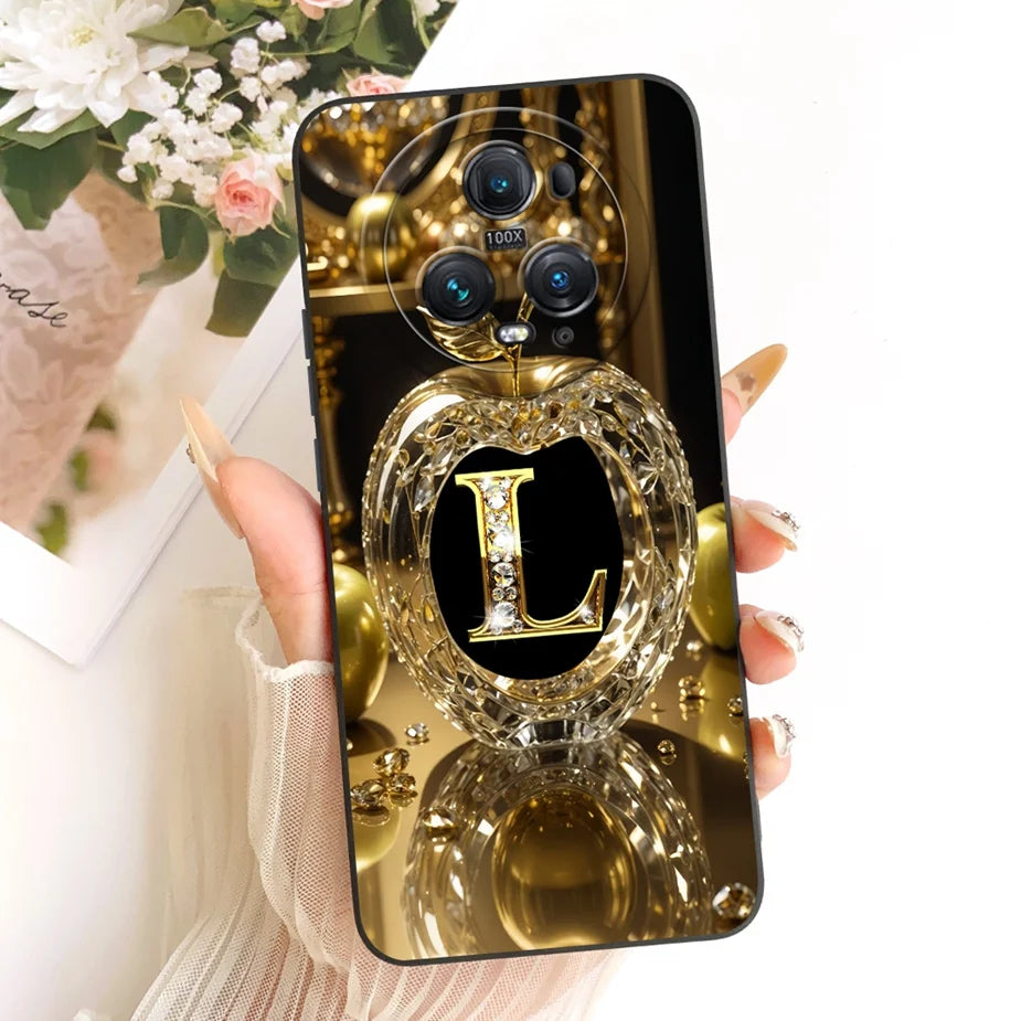 Honor Magic 5 Hülle mit goldenem Kristall-Apfel-Motiv und diamantbesetztem Buchstaben L auf schwarzem Hintergrund
