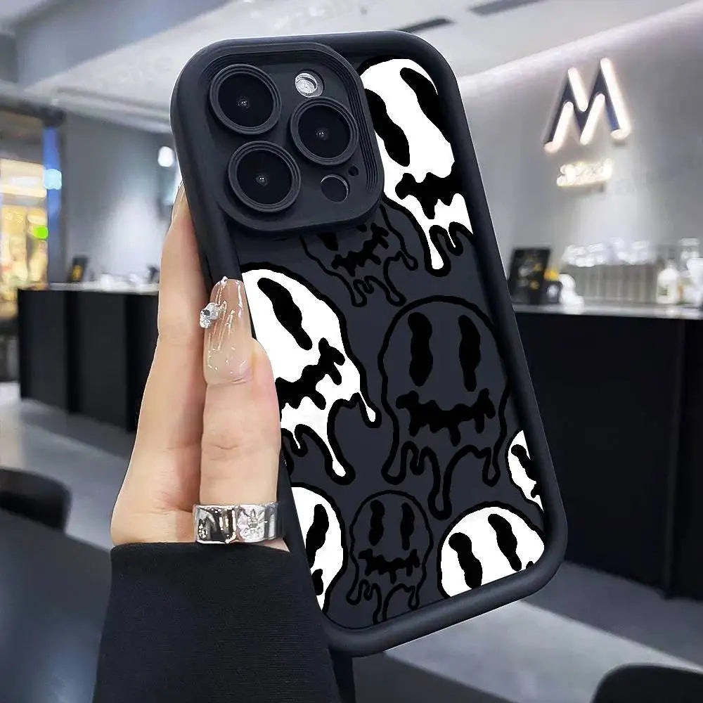Hand hält schwarze iPhone-Hülle mit weiß-schwarzem Dripping-Smiley-Allover-Print, Rückansicht
