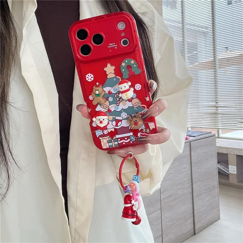 Hand hält rote iPhone-Hülle mit 3D-Weihnachtsbaum-Szene, Weihnachtsmann, Rentier und rotem Perlenarmband